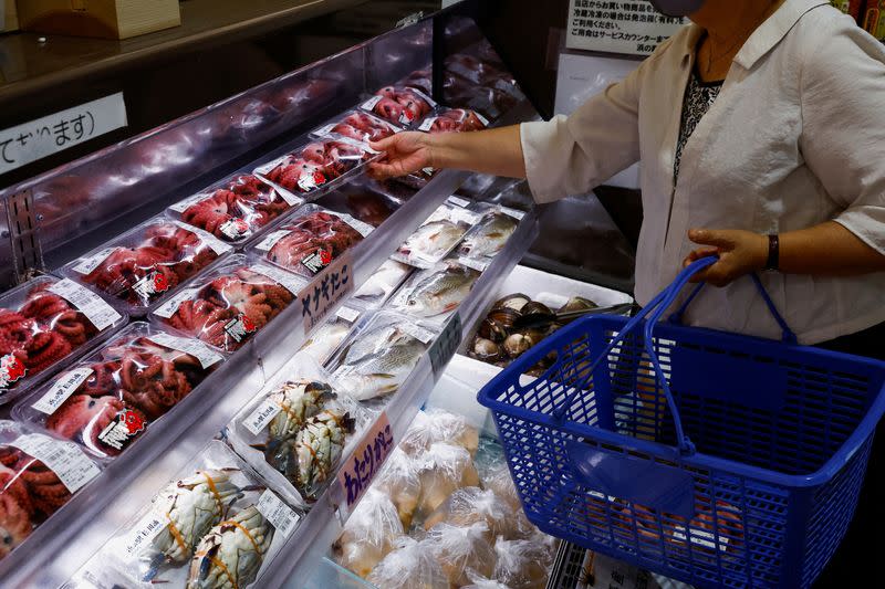 A customer browses through locally caught seafood at the Hamanoeki Fish Market and Food Court in Soma