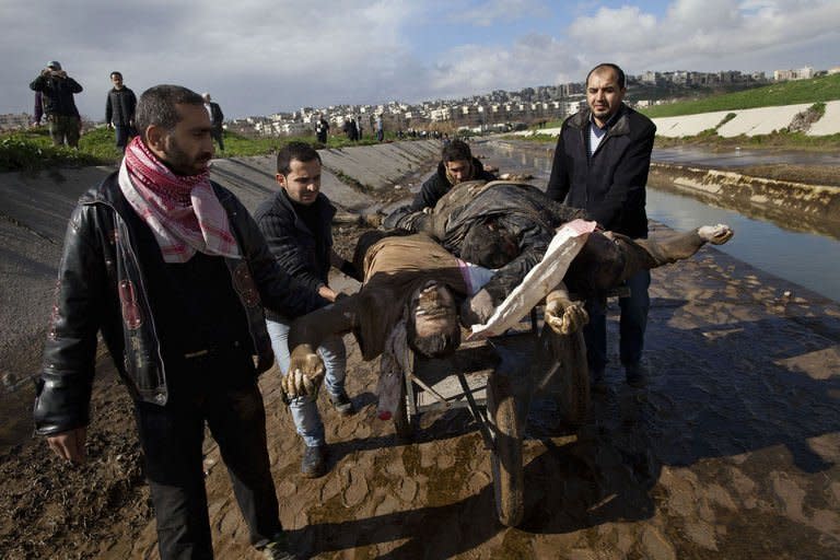 Syrians recover the bodies of executed men along a canal in the northern city of Aleppo before transferring the corpses to a hospital where relatives could seek to identify them, on January 29, 2013. The gruesome discovery came ahead of a briefing by peace envoy Lakhdar Brahimi to the UN Security Council on the uprising, which the United Nations says has left more than 60,000 people dead