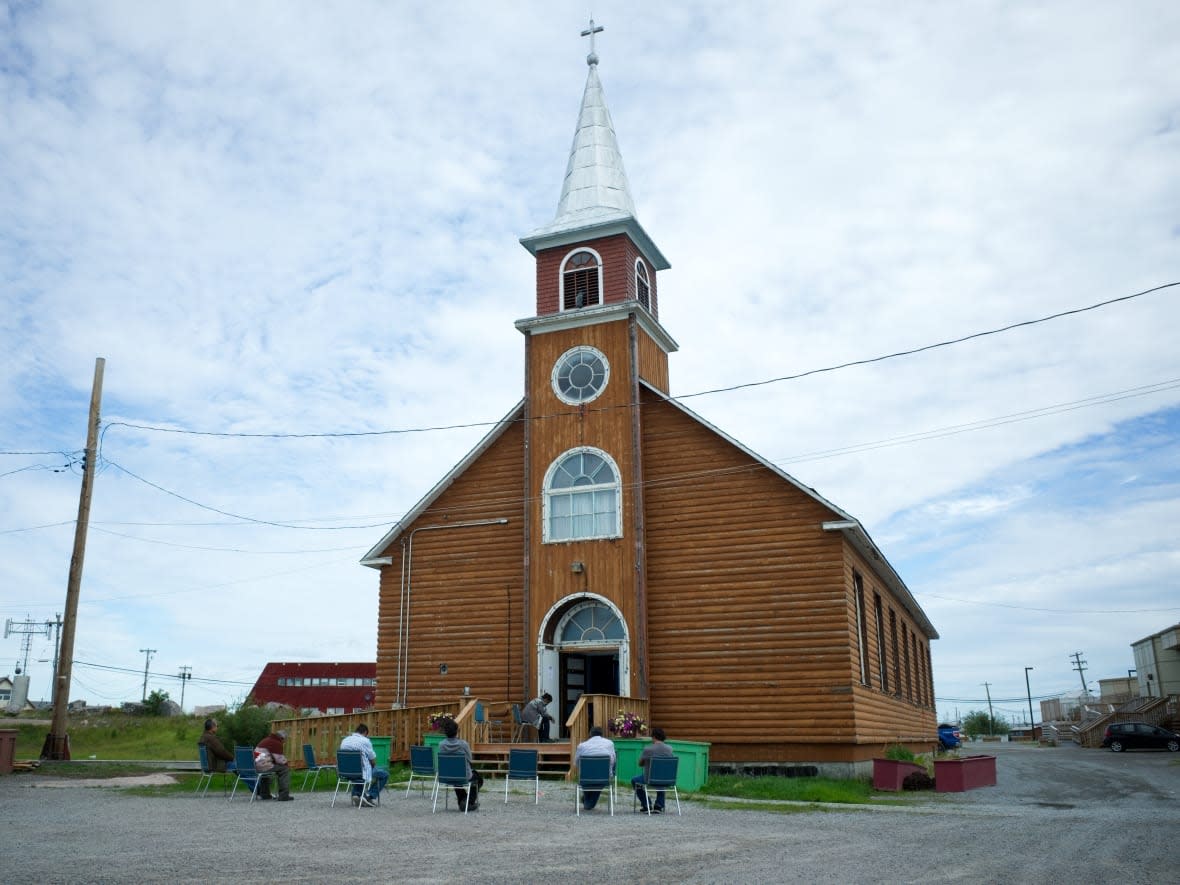 Congregants at a Roman Catholic mass in Behchokǫ̀ sit outside the church during COVID-19 physical distancing protocols on Aug. 9, 2020.  (Walter Strong/CBC - image credit)