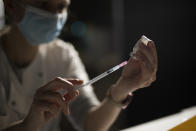 Nurse Coralie Ferron prepares a dose of the Moderna COVID-19 vaccine at a vaccination center in Le Cannet, southern France, Thursday Jan. 21, 2021. (AP Photo/Daniel Cole)