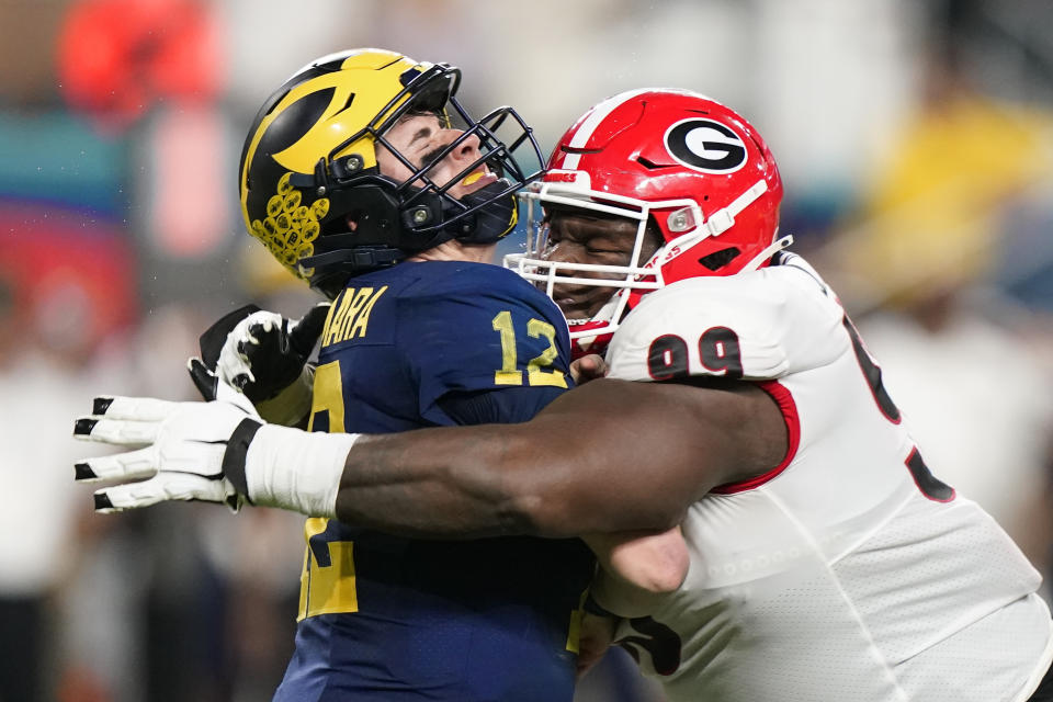 Georgia defensive lineman Jordan Davis hits Michigan quarterback Cade McNamara during the second half of the Orange Bowl NCAA College Football Playoff semifinal game, Friday, Dec. 31, 2021, in Miami Gardens, Fla. (AP Photo/Lynne Sladky)