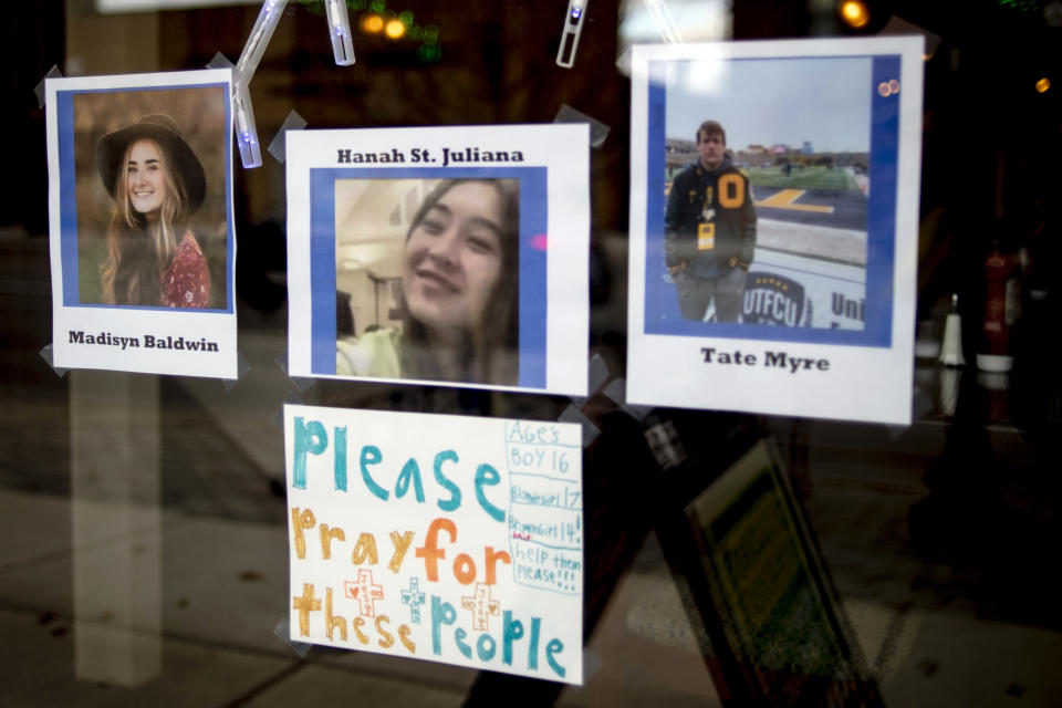 Photos of three of the four teens killed in the Oxford High School shooting are posted on the window at Sullivan's Public House Restaurant and Bar on Thursday, Dec. 2, 2021 in Oxford, Mich. A 15-year-old sophomore opened fire at his Michigan high school on Tuesday, killing four students, including a 16-year-old boy who died in a deputy’s patrol car on the way to a hospital, authorities said. (Jake May/The Flint Journal via AP)