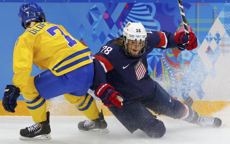 Team USA's Kacey Bellamy (R) is checked by Sweden's Johanna Olofsson during the first period of their women's ice hockey semi-final game at the Sochi 2014 Winter Olympic Games February 17, 2014. REUTERS/Laszlo Balogh (RUSSIA - Tags: SPORT ICE HOCKEY OLYMPICS)