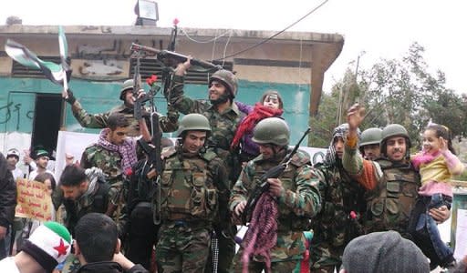 Syrian soldiers who defected join protesters in the al-Khaldiya neighborhood of the restive city of Homs on January 26, 2012. The Britain-based Syrian Observatory for Human Rights said the army launched an offensive on Thursday evening in the Karm al-Zeitoun district of Homs, killing 26 civilians, including nine children, and wounding dozens