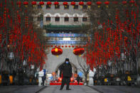 FILE - In this Feb. 16, 2020, file photo, a security guard wearing a face mask walks through a quiet main Qianmen Street, a popular tourist spot in Beijing. As the coronavirus spreads around the world, International health authorities are hoping countries can learn a few lessons from China, namely, that quarantines can be effective and acting fast is crucial. On the other hand, the question before the world is to what extent it can and wants to replicate China’s draconian methods. (AP Photo/Andy Wong, File)