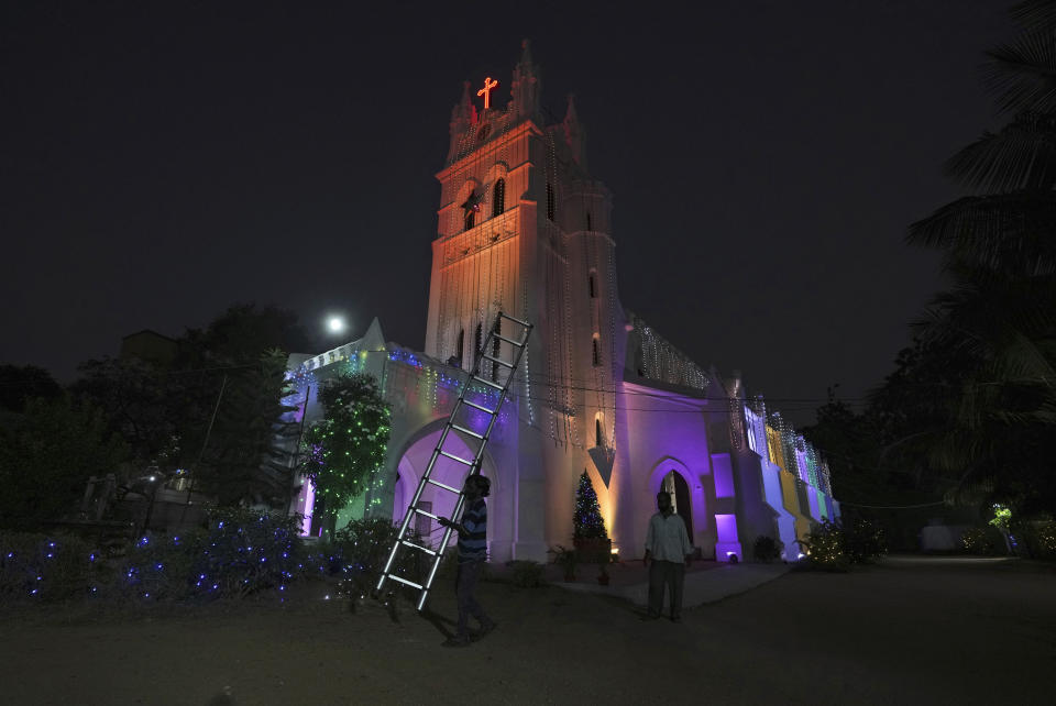 A worker decorates a church with fairy lights on the eve of Christmas in Hyderabad, India, Saturday, Dec. 24, 2022. Though the Hindus and Muslims comprise majority of the population in India, Christmas is a national holiday celebrated with much fanfare. (AP Photo/Mahesh Kumar A.)