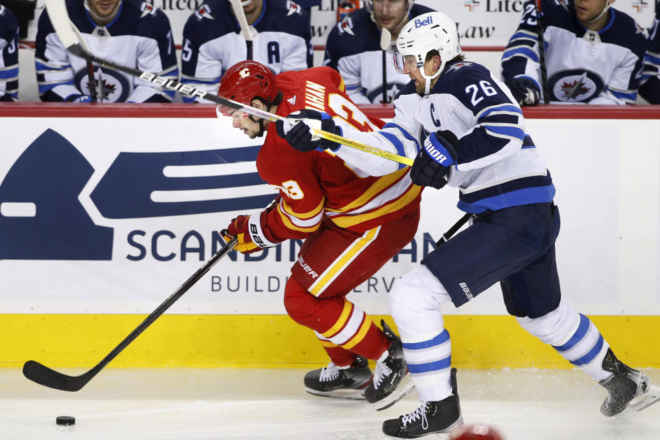 Winnipeg Jets' Blake Wheeler, right, chases Calgary Flames' Sean Monahan during the second period of an NHL hockey game Saturday, Nov. 27, 2021, in Calgary, Alberta. (Larry MacDougal/The Canadian Press via AP)