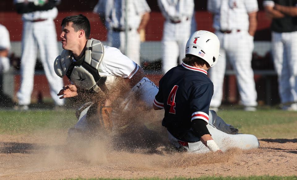 Ketcham's Connor Lynch (4) slides safe into home as he steals home in front of Arlington catcher Joe Ruppert during baseball action at Arlington High School in LaGrangeville April 22, 2022. Ketcham won the game 9-4.