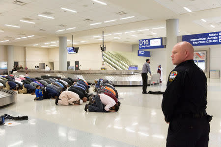 FILE PHOTO - People gather to pray in baggage claim during a protest against the travel ban imposed by U.S. President Donald Trump's executive order, at Dallas/Fort Worth International Airport in Dallas, Texas, U.S. on January 29, 2017. REUTERS/Laura Buckman/File Photo