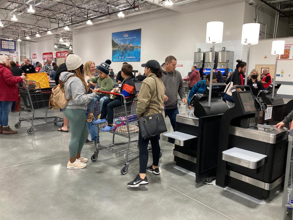Customers wait to check out inside a new Costco on the morning of opening day, Tuesday, Nov. 22, 2022. The store has 17 check out lanes and eight self checkout lanes.