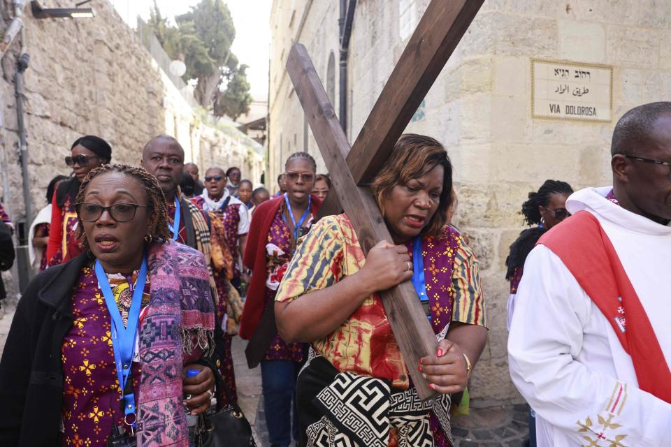 Pilgrims carry a wooden cross along the Via Dolorosa (Way of Suffering) in Jerusalem's Old City during the Catholic Good Friday procession on April 7, 2023.