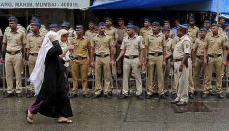 Policemen stand guard as women walk pass near the residence of Yakub Memon, in Mumbai, India, July 30, 2015. REUTERS/Shailesh Andrade