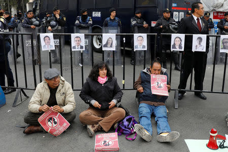 Activists hold a protest against a law that militarises crime fighting in the country outside the Senate in Mexico City, Mexico December 14, 2017. Placards read, "No to the Militarisation in the Country". Picture taken December 14, 2017. REUTERS/Carlos Jasso