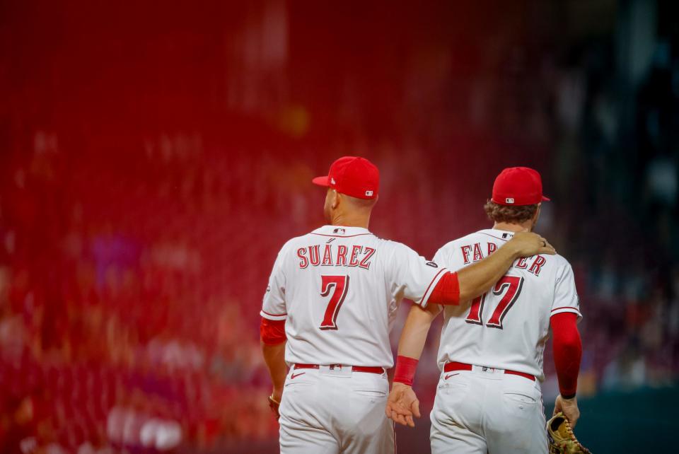 Former Cincinnati Reds third baseman Eugenio Suarez puts his arm around former Reds shortstop Kyle Farmer. Both players were a part of a series of rebuilding-centered moves by the Reds.