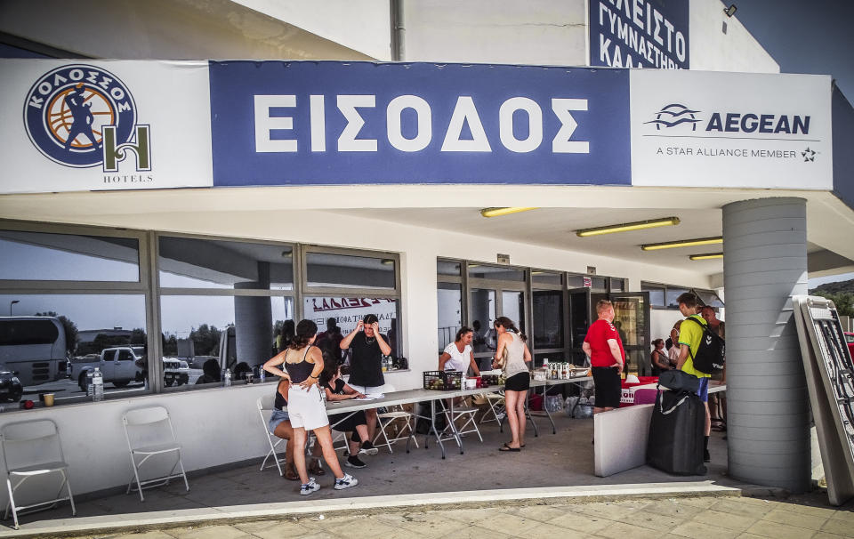 The entrance of a stadium where evacuees from a forest fire are gathered, on the island of Rhodes, Greece, Sunday, July 23, 2023. Some 19,000 people have been evacuated from the Greek island of Rhodes as wildfires continued burning for a sixth day on three fronts, Greek authorities said on Sunday. (Argyris Mantikos/Eurokinissi via AP)