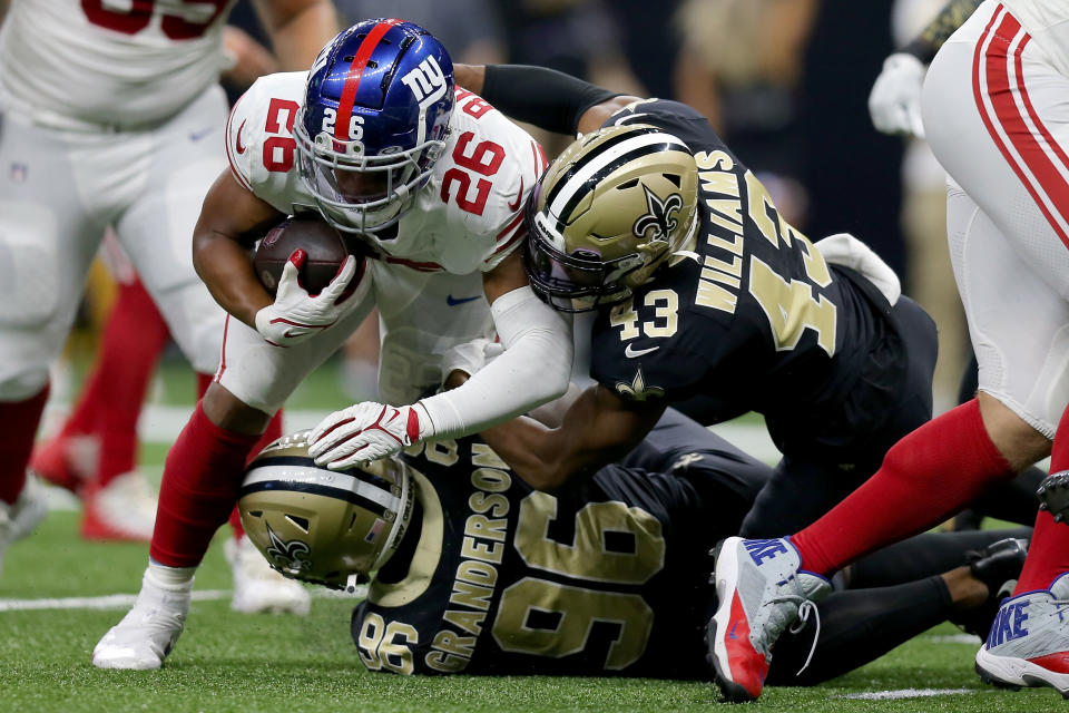 NEW ORLEANS, LOUISIANA - OCTOBER 03: Saquon Barkley #26 of the New York Giants is tackled by Carl Granderson #96 and Marcus Williams #43 of the New Orleans Saints during the third quarter at Caesars Superdome on October 03, 2021 in New Orleans, Louisiana. (Photo by Jonathan Bachman/Getty Images)