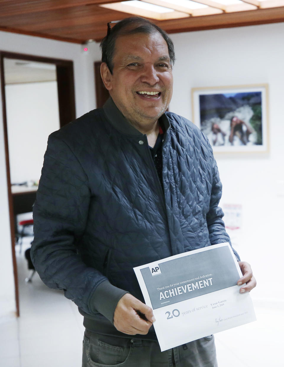 Associated Press reporter Cesar Garcia poses for a photo as he marks his 20 year anniversary with the AP at his office in Bogota, Colombia, Friday, May 31, 2019. Garcia, a veteran reporter who ventured across Colombia to tell the story of the nation’s armed conflict, has died at age 61. (AP Photo/Fernando Vergara)