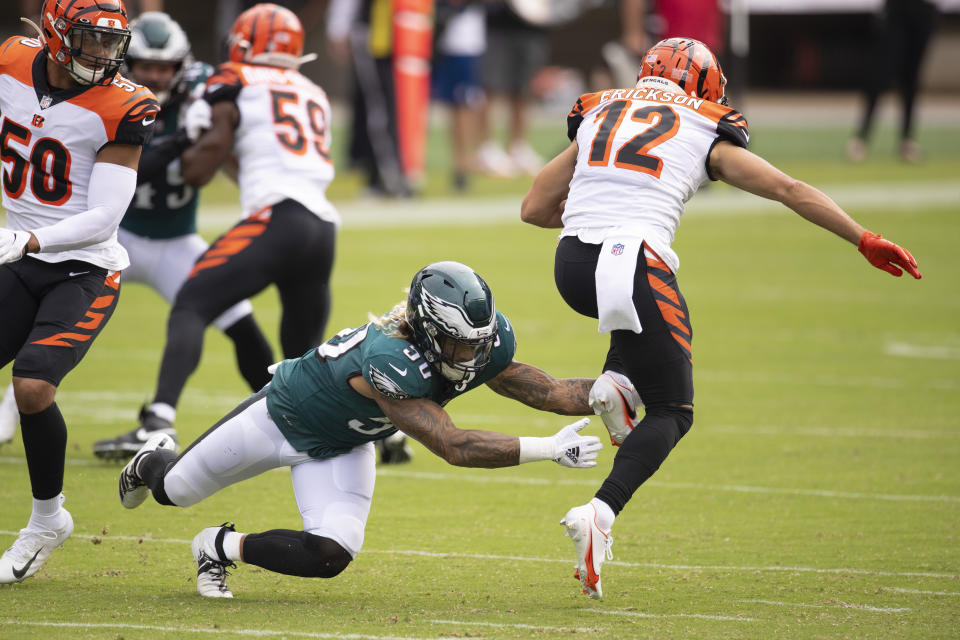 An Eagles player tries and fails to tackle a Bengals player.