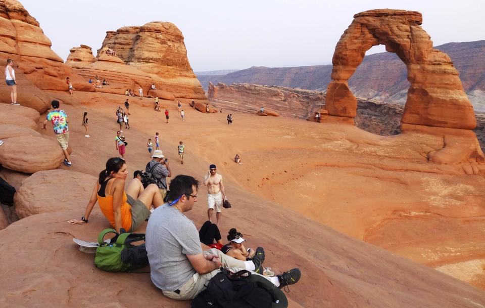 Tourists gather at the Arches National Park in Moab, Utah in this file photo from August 16, 2012. Utah will reopen its national parks and monuments under a deal with the U.S. Department of the Interior, which closed the sites and other parks across the country as part of the partial federal government shutdown that began on Oct. 1. REUTERS/Charles Platiau/Files (UNITED STATES - Tags: ENVIRONMENT TRAVEL)