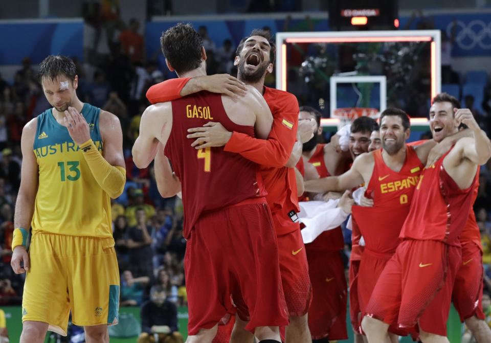 Australia's David Andersen (left) walks off the court as Spain's Pau Gasol and Jose Calderon celebrate their bronze-medal win at the 2016 Summer Olympics in Rio de Janeiro, Brazil. (AP/Eric Gay)