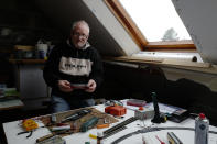 Guy Warein, a 70-year-old retiree, works on model trains in his home in Richebourg, northern France, Wednesday, Jan. 27, 2021. The old-school pastimes of making scale models and playing with miniature trains are making a comeback as a form of therapy against the pandemic blues. Sales are booming as locked-down families glue and paint models and dust off train sets. (AP Photo/Michel Spingler)