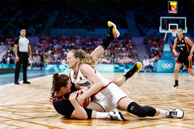 La número 13 de Bélgica, Kyara Linskens (izq.), y la número 11 de Alemania, Marie Guelich, disputan la pelota en el partido de baloncesto del grupo C de la ronda preliminar femenina entre Alemania y Bélgica durante los Juegos Olímpicos de París 2024 en el estadio Pierre-Mauroy en Villeneuve-d'Ascq, norte de Francia, el 29 de julio de 2024. (Foto de Sameer Al-Doumy / AFP)