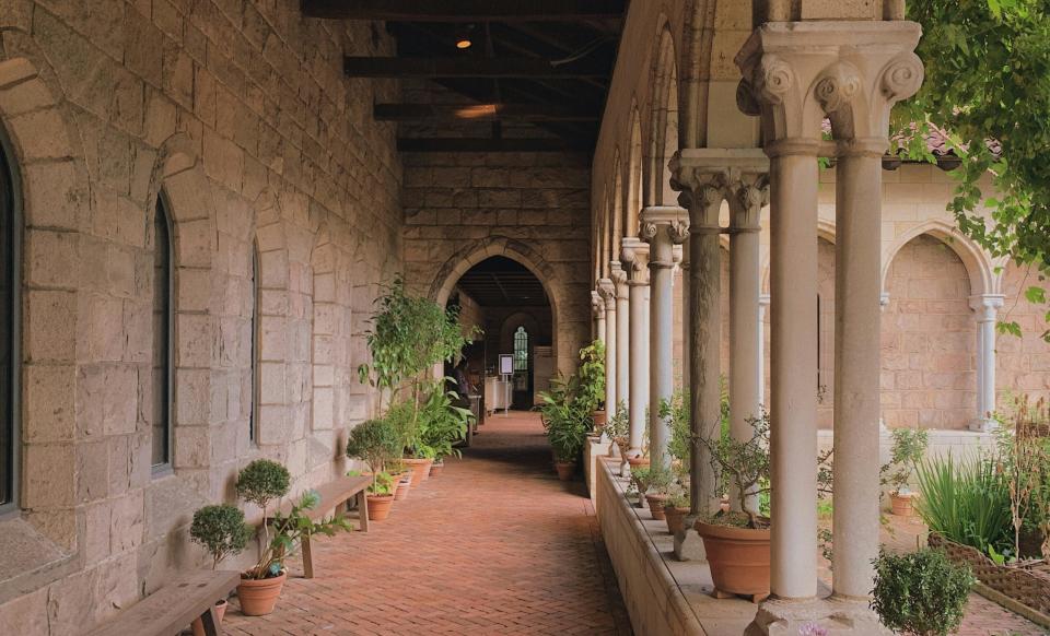 Check out these intriguing castles that are located in New York.
pictured: a corridor with a cobblestone walkway and columns 