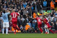 Liverpool's Philippe Coutinho, second right, celebrates after scoring the winning goal against Manchester City during their English Premier League soccer match at Anfield Stadium, Liverpool, England, Sunday April 13, 2014. (AP Photo/Jon Super)