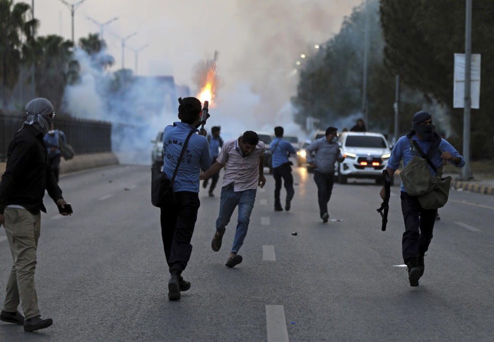 Police fire tear gas to disperse supporters of Pakistan's key opposition party marching in Islamabad, Pakistan, Wednesday, May 25, 2022. Pakistani authorities blocked off all major roads into the capital Islamabad on Wednesday, after a defiant former Prime Minister Imran Khan said he would march with demonstrators to the city center for a rally he hopes will bring down the government and force early elections. (AP Photo/Rahmat Gul)