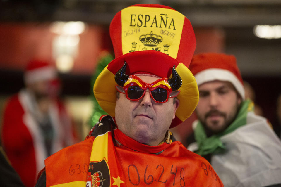 A man dressed in a costume waits for the start of the Christmas lottery draw at Madrid's Teatro Real opera house during Spain's bumper Christmas lottery draw in Madrid, Spain, Sunday, Dec. 22, 2019. The lottery, known as El Gordo, or The Fat One, will dish out 2.24 billion euros ($2.43 billion) in prizes. (AP Photo/Paul White)