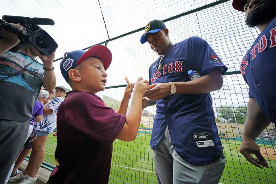 Boston Red Sox's Jeurys Familia, right, gives an autograph during a visit to the Little League World Series in South Williamsport, Pa., Sunday, Aug. 21, 2022. The Red Sox play the Baltimore Orioles in the Little League Classic on Sunday Night Baseball. (AP Photo/Gene J. Puskar)