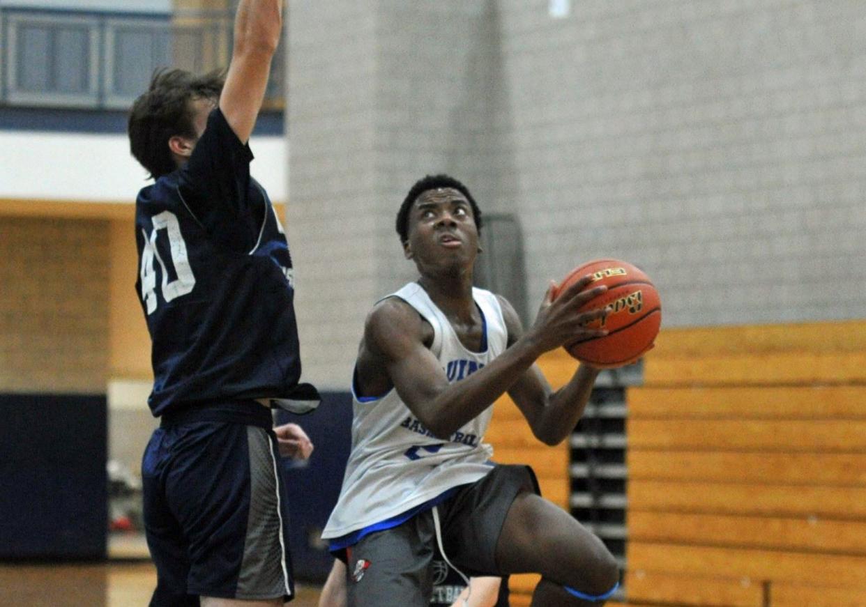 Quincy's Danny Adams, right, goes for a layup as Cohasset's Sam Larsen, left, defends during a boys basketball preseason scrimmage at Quincy High School, Thursday, Dec. 7, 2023.