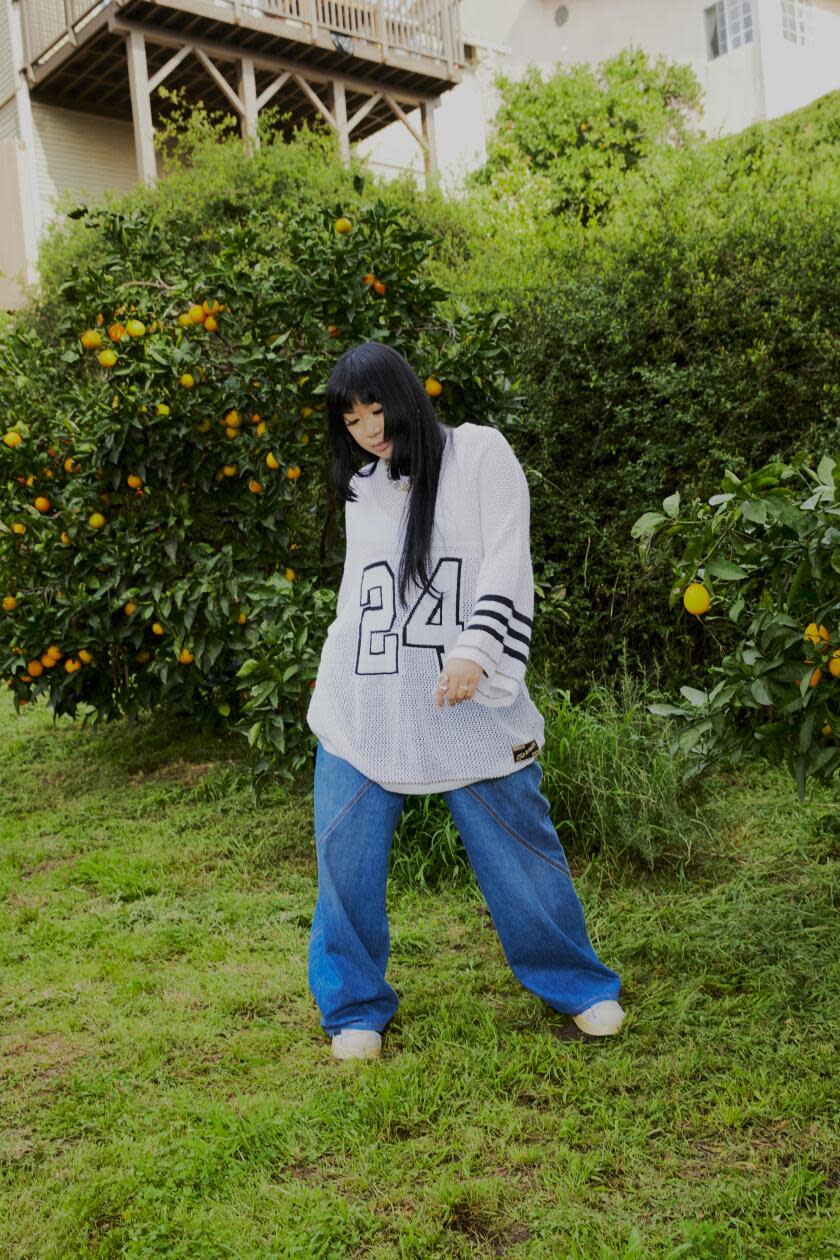 Jess wears Nahmias sweater, JW Anderson pants, Adidas shoes, Vitaly necklace.