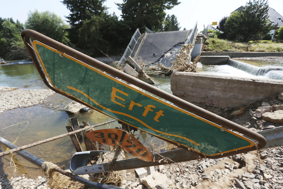 A location sign for the river Erft lies in the rubble in front of a destroyed bridge, in Stotzheim, Germany Thursday July 22, 2021. Heavy rains have caused devastating floods over much of the region, (David Young/dpa via AP)