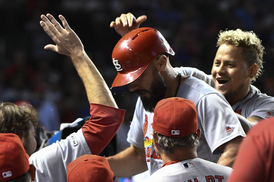 St. Louis Cardinals' Matt Carpenter, center, celebrates in the dugout with relief pitcher Carlos Martinez, right, after he hit a home run against the Chicago Cubs during the tenth inning of a baseball game Thursday, Sept. 19, 2019, in Chicago. (AP Photo/Matt Marton)