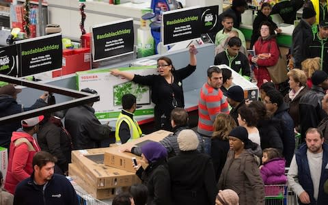 Customers surrounded by shelves on Black Friday in Asda - Credit: Simon Dawson/Bloomberg News