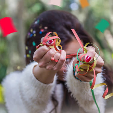 Woman holding confetti in front of face web