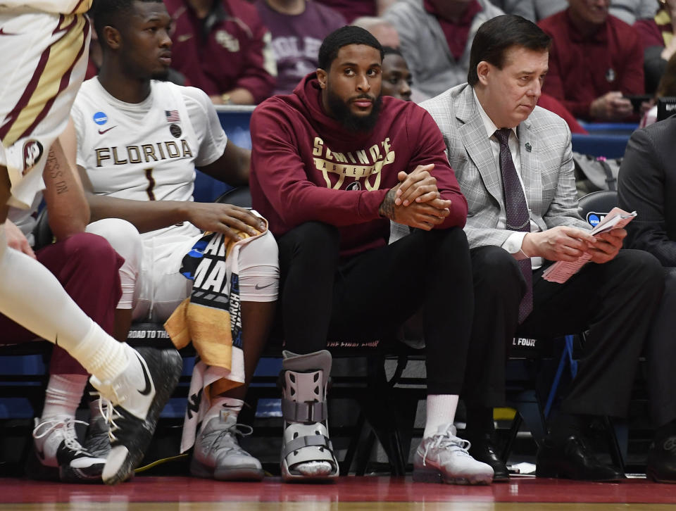 Florida State's Phil Cofer (0) sits on the bench with a boot on his right foot during the second half of a first round men's college basketball game against Vermont in the NCAA tournament, Thursday, March 21, 2019, in Hartford, Conn. (AP Photo/Jessica Hill)