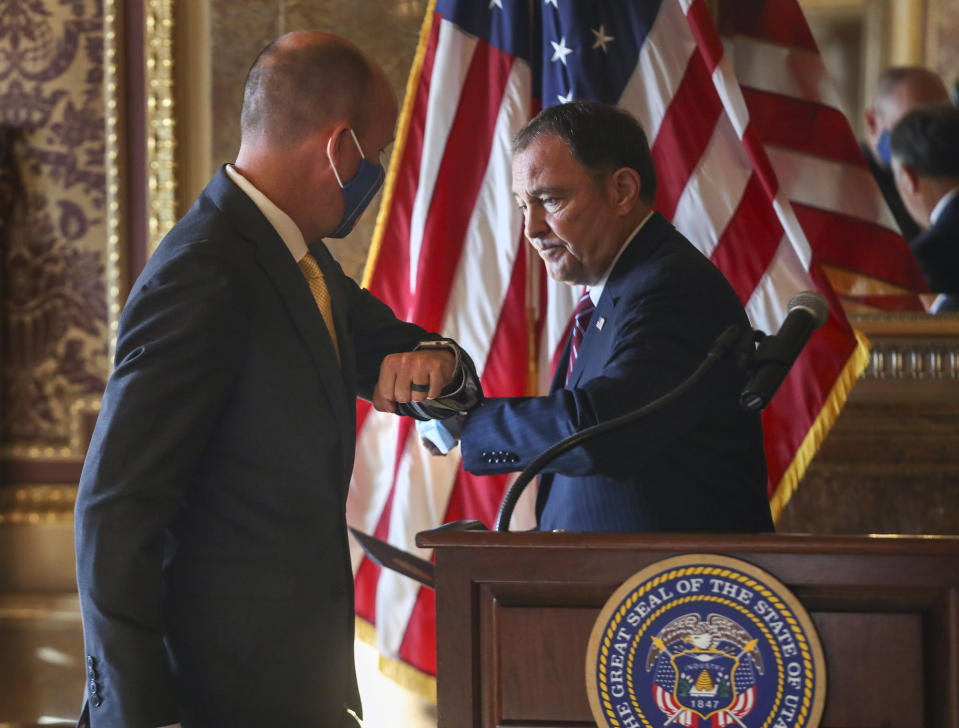 Gov. Gary Herbert, right, and Gov.-elect Spencer Cox exchange elbows during a press conference announcing details related to their upcoming transition of leadership at the Utah State Capitol on Thursday, Nov. 5, 2020, in Salt Lake City. Cox, who won the governor's race this week, said he is prepared to continue the fight against COVID-19 when he succeeds Herbert in January. He said he hopes to focus on ramping up testing, adding more contact tracers and implementing vaccine distribution. (Steve Griffin/Deseret News, via AP, Pool)