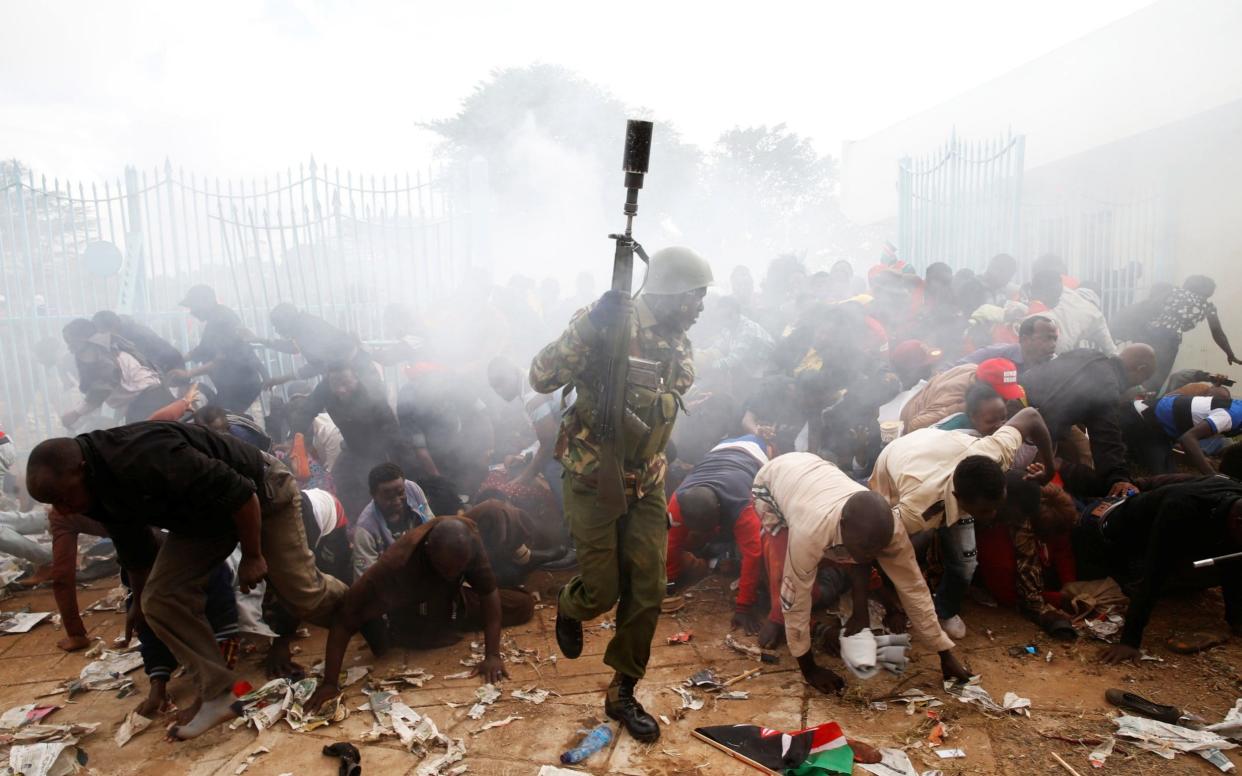 People fall as police fire tear gas to try to control a crowd trying to force their way into a stadium to attend the inauguration of President Uhuru Kenyatta at Kasarani Stadium in Nairobi  - REUTERS