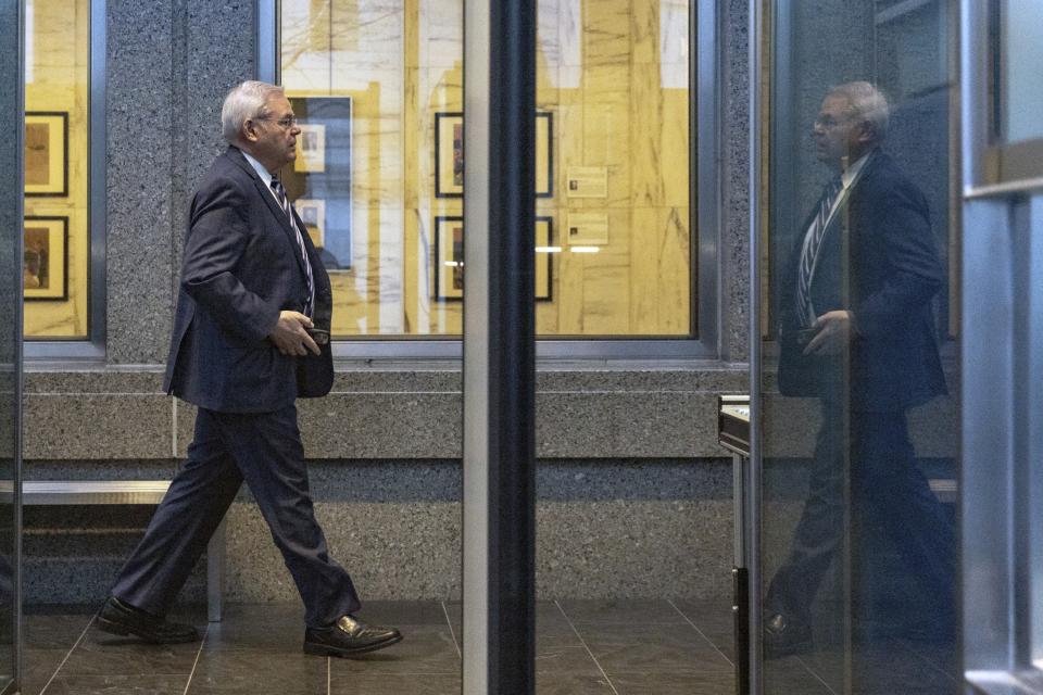 Menendez walks down a hallway in the court building.