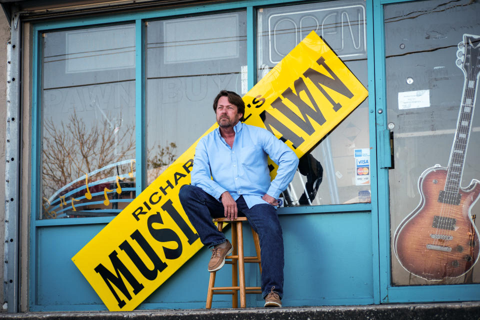 Richard Hill sits in front of his pawn shop, which is now closed for business, in South Daytona, Florida. (Dylan Hill)