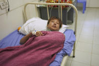 Survivor Huang Qian, 20, from Hunan province in China, recuperates in a hospital bed, Saturday, Sept. 24, 2022, Preah Sihanouk Province, Southwestern Cambodia after being rescued from a sinking boat days earlier. Authorities are searching for multiple people in the surrounding waters after their boat sank near Cambodia's Koh Tang island on Thursday. (AP Photo/Heng Sinith)