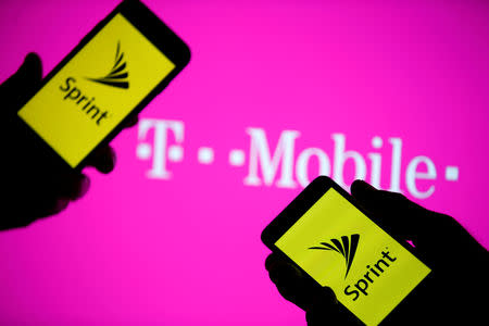 A smartphones with Sprint logo are seen in front of a screen projection of T-mobile logo, in this picture illustration taken April 30, 2018. REUTERS/Dado Ruvic/Illustration