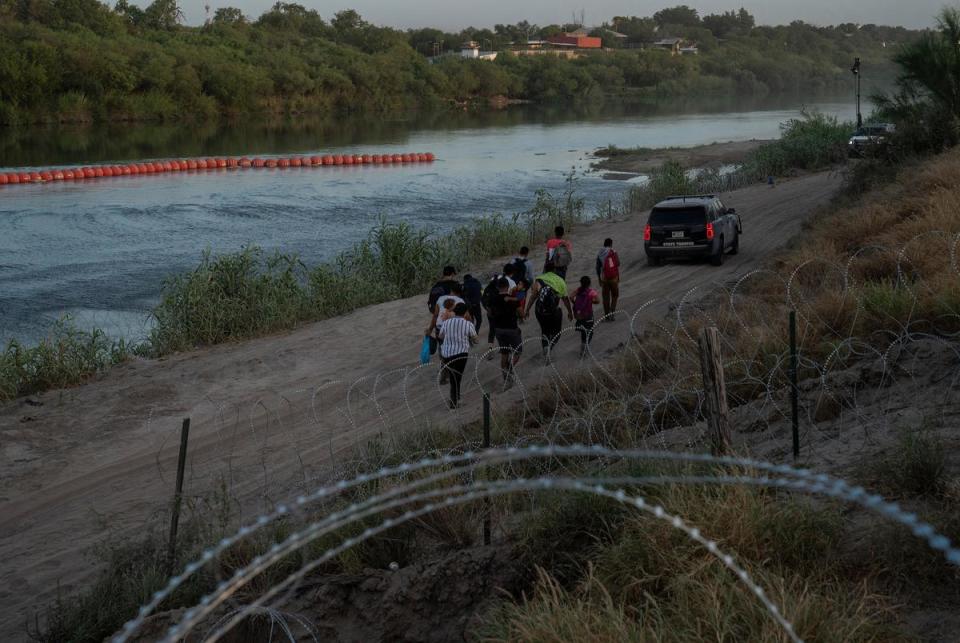 A group of migrants follow a state trooper vehicle after turning themselves in in Eagle Pass, Texas on July 29, 2023. They crossed through a cap in the concertina wire in the Urbina’s property. Some will be sent back after being arrested for trespassing private property without allowing them to go through the immigration process in the U.S.
Verónica G. Cárdenas for The Texas Tribune