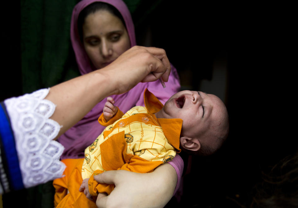 A Pakistani health worker gives a polio vaccine to a child in Rawalpindi, Pakistan, Tuesday, May 6, 2014. Pakistan’s health minister says the country is taking extra ordinary measures to meet the new situation it is going to face after polio travel restrictions. (AP Photo/B.K. Bangash)