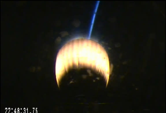 The second stage engine on SpaceX's upgraded Falcon 9 v1.1 rocket glows red with the blue airglow of Earth's atmosphere in the background during the company's launch of the SES-8 communications satellite from Cape Canaveral Air Force Station, F