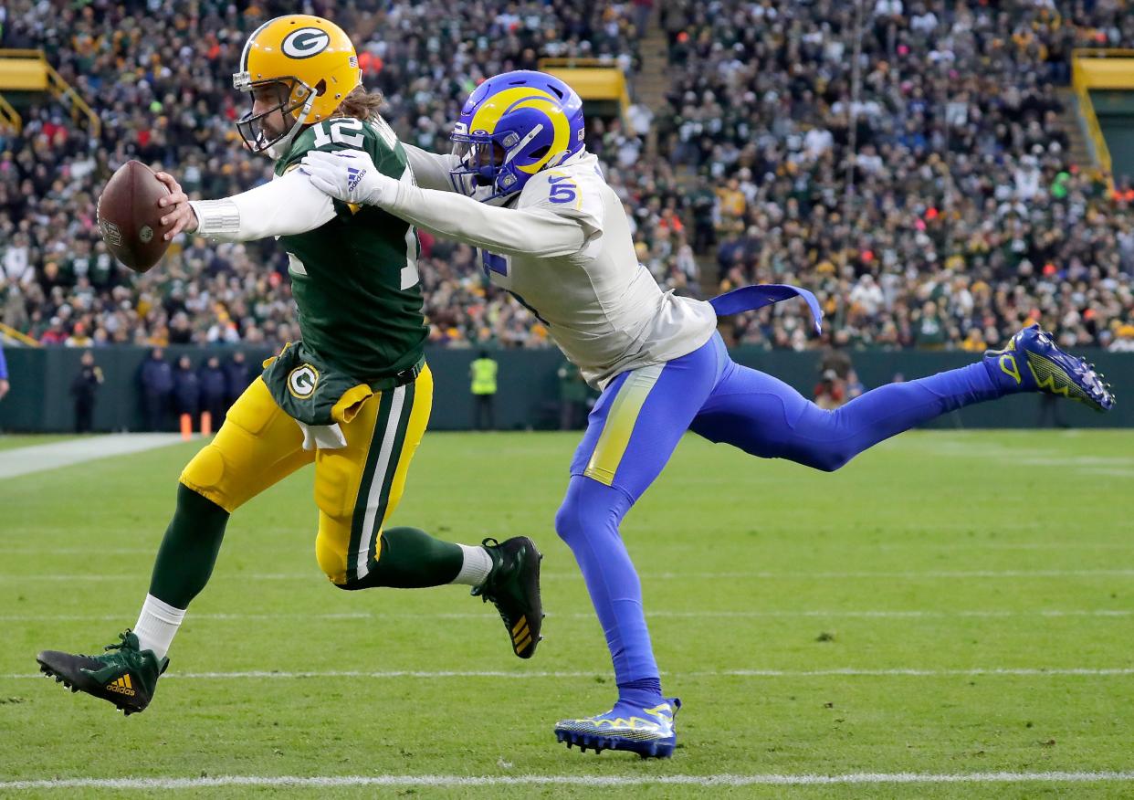 Green Bay Packers quarterback Aaron Rodgers (12) rushes for a first quarter touchdown against Los Angeles Rams cornerback Jalen Ramsey (5) during their football game on Sunday November 28, 2021, at Lambeau Field in Green Bay, Wis.