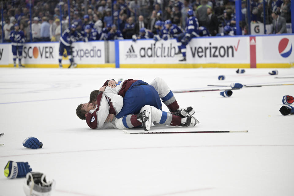 Colorado Avalanche center Nathan MacKinnon, top, and defenseman Erik Johnson celebrate the team's 2-1 win in the NHL hockey Stanley Cup Finals against the Tampa Bay Lightning on Sunday, June 26, 2022, in Tampa, Fla. (AP Photo/Phelan Ebenhack)