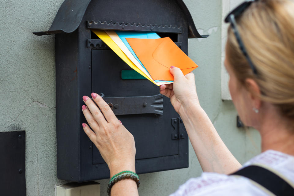 Woman is holding colorful envelopes. Postal worker delivering correspondence